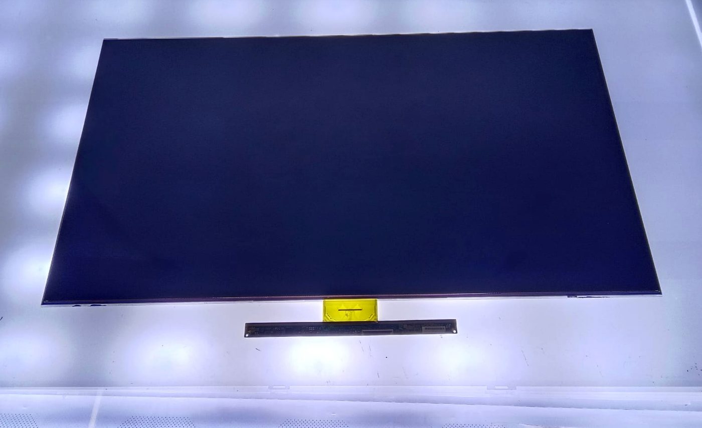 Open LCD TV panel with COF ribbon and source board on the backlight test table